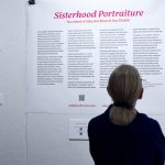 Woman reading exhibition wall text.