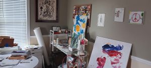 a blank roll of canvas in the corner of a messy art studio