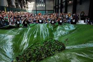 Photo of many people around a large salad
